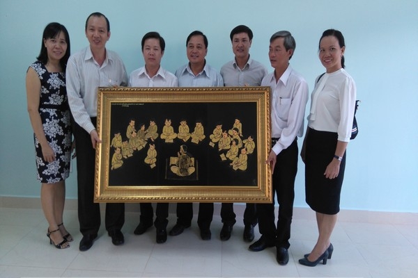 Đồng chí Bùi Xuân Đức - Chủ tịch Liên hiệp và các đồng chí trong đoàn tặng bức tranh cho Thư viện Bình Phước